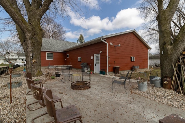 back of property featuring a patio and an outdoor fire pit