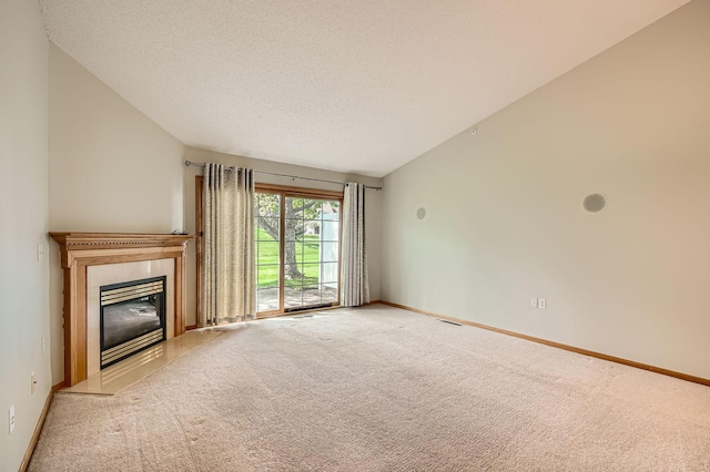unfurnished living room with carpet floors, a high end fireplace, baseboards, and a textured ceiling
