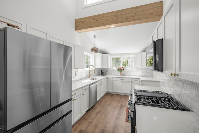 613 Cromwell Ave, Saint Paul, MN 55104 - kitchen featuring appliances with stainless steel finishes, tasteful backsplash, a sink, and white cabinetry