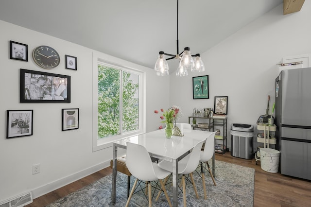 613 Cromwell Ave, Saint Paul, MN 55104 - dining room featuring a chandelier, dark wood-type flooring, baseboards, and lofted ceiling