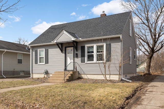 view of front facade with a chimney, a front lawn, and a shingled roof