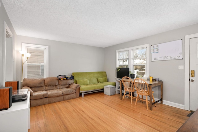 living area with a textured ceiling and light wood-type flooring