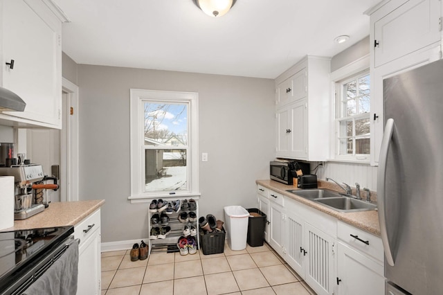 kitchen with a wealth of natural light, stainless steel appliances, light countertops, and a sink