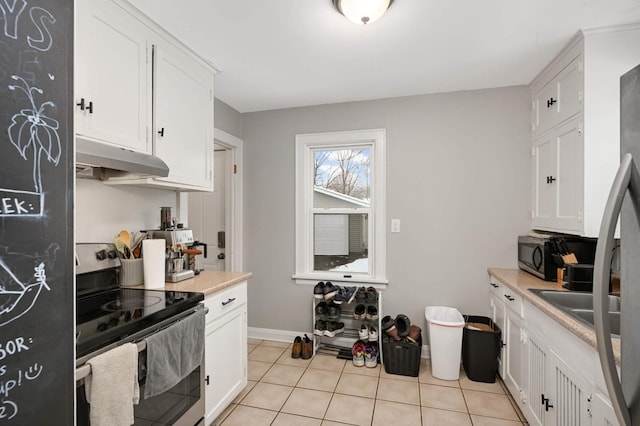 kitchen featuring stainless steel appliances, white cabinetry, light countertops, under cabinet range hood, and light tile patterned floors