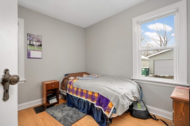bedroom featuring visible vents, baseboards, and wood finished floors