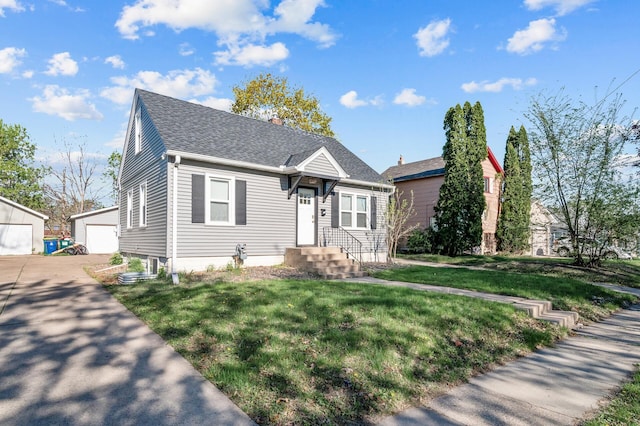 3806 Jackson St NE, Columbia Heights, MN 55421 - view of front of property featuring a front yard, an outbuilding, a garage, and a shingled roof