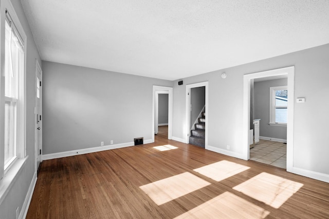 3806 Jackson St NE, Columbia Heights, MN 55421 - unfurnished living room with stairs, wood finished floors, and baseboards