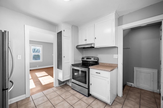 3806 Jackson St NE, Columbia Heights, MN 55421 - kitchen featuring appliances with stainless steel finishes, white cabinetry, light tile patterned floors, light countertops, and under cabinet range hood