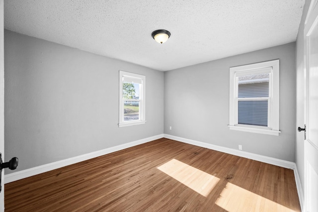 3806 Jackson St NE, Columbia Heights, MN 55421 - empty room with wood finished floors, a textured ceiling, and baseboards