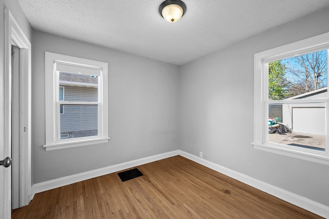 3806 Jackson St NE, Columbia Heights, MN 55421 - empty room featuring wood finished floors, baseboards, and a textured ceiling