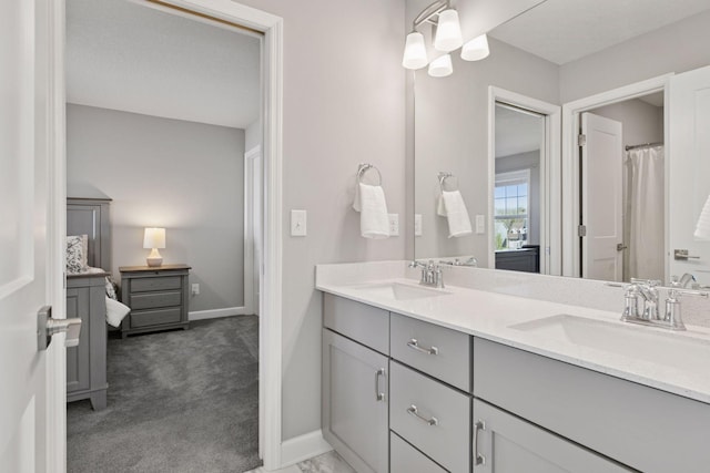 full bath featuring double vanity and baseboards
