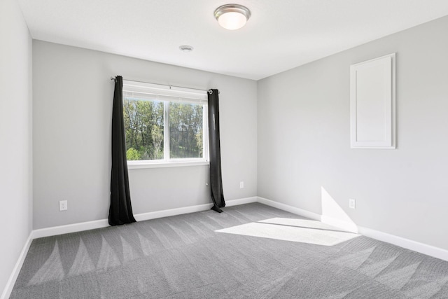 unfurnished room featuring carpet flooring and baseboards