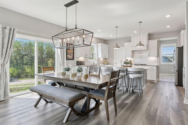 dining area with wood finished floors, a chandelier, and recessed lighting