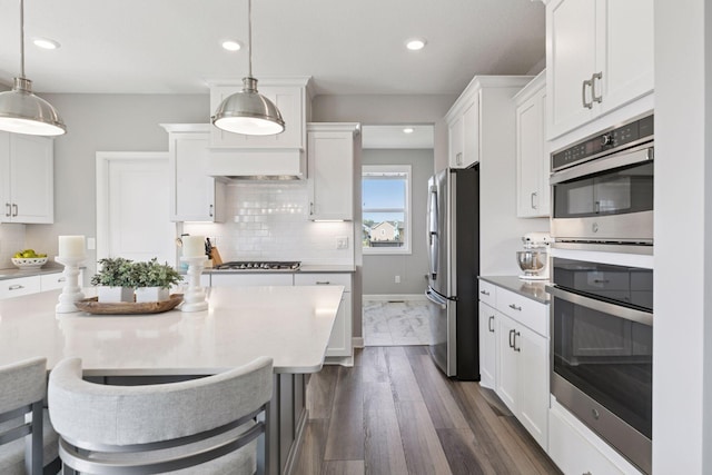kitchen featuring stainless steel appliances, white cabinets, tasteful backsplash, decorative light fixtures, and recessed lighting