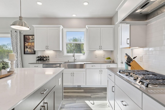 kitchen featuring a sink, under cabinet range hood, appliances with stainless steel finishes, plenty of natural light, and recessed lighting