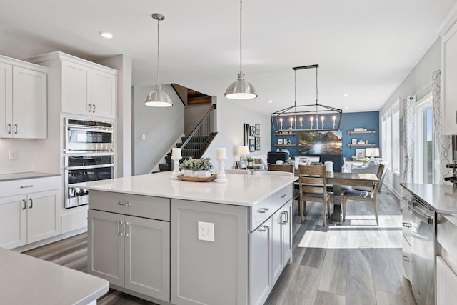 kitchen featuring light countertops, dark wood-style flooring, open floor plan, white cabinets, and a center island
