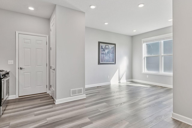 empty room with wood finished floors, recessed lighting, and baseboards