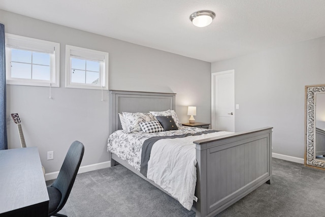 bedroom with dark carpet and baseboards