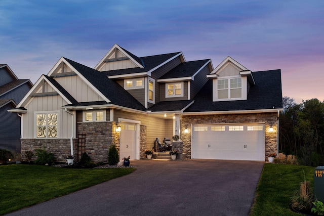 craftsman inspired home featuring board and batten siding, asphalt driveway, stone siding, a lawn, and a shingled roof