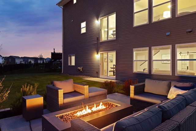 patio terrace at dusk with an outdoor living space with a fire pit and a yard