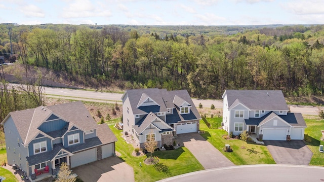 aerial view of property and surrounding area featuring a heavily wooded area