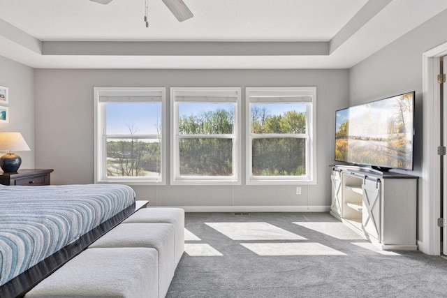 bedroom featuring carpet flooring, a raised ceiling, ceiling fan, and baseboards