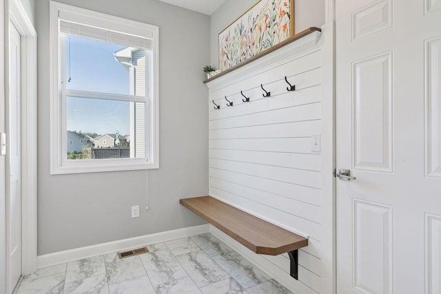 mudroom featuring light marble finish flooring and baseboards