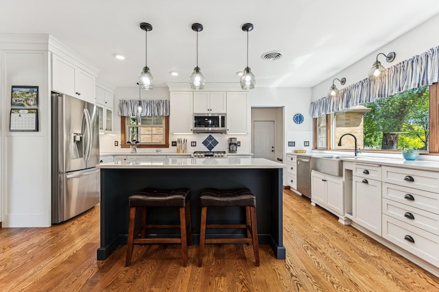 319 Meadow Ln, Benson, MN 56215 - kitchen with stainless steel appliances, light countertops, a kitchen island, white cabinets, and recessed lighting