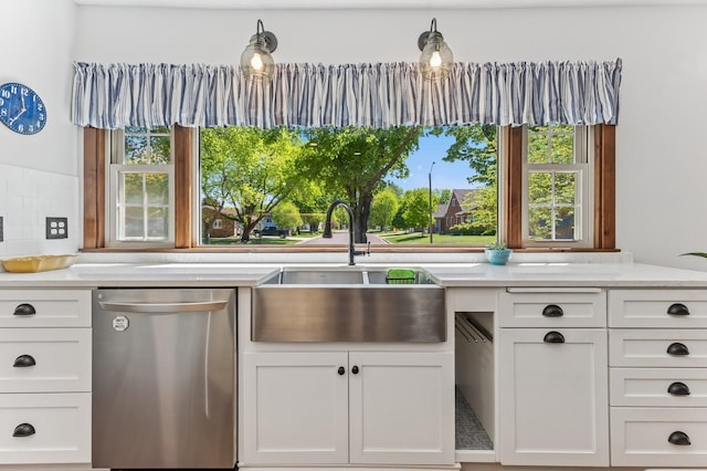 319 Meadow Ln, Benson, MN 56215 - kitchen featuring stainless steel dishwasher, a sink, white cabinets, and healthy amount of natural light