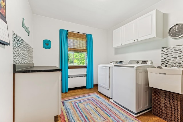 319 Meadow Ln, Benson, MN 56215 - laundry room with cabinet space, light wood-style flooring, and independent washer and dryer