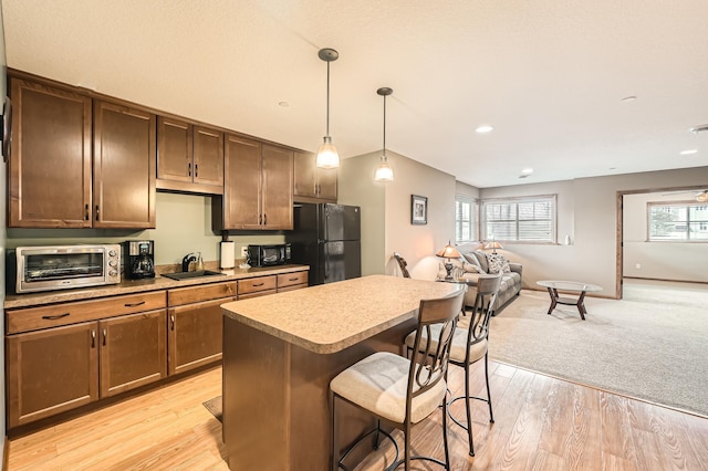20620 Everton Way N, Forest Lake, MN 55025 - kitchen with freestanding refrigerator, a sink, open floor plan, a breakfast bar, and plenty of natural light