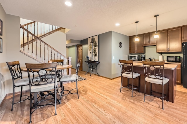 20620 Everton Way N, Forest Lake, MN 55025 - kitchen with light wood finished floors, black appliances, pendant lighting, baseboards, and a breakfast bar area