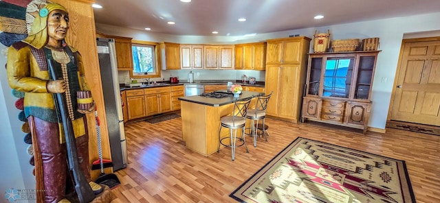 29972 293rd St, Little Elbow Twp, MN 56589 - kitchen featuring dishwasher, light wood-style floors, a sink, a breakfast bar area, and a kitchen island