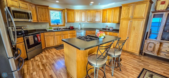 29972 293rd St, Little Elbow Twp, MN 56589 - kitchen featuring appliances with stainless steel finishes, dark countertops, light wood-style flooring, a breakfast bar, and a sink