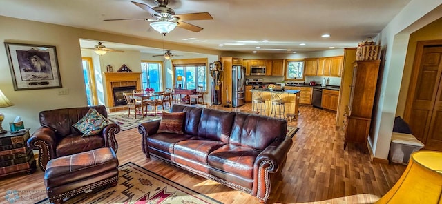 29972 293rd St, Little Elbow Twp, MN 56589 - living room with light wood-style flooring, a ceiling fan, recessed lighting, and a fireplace with raised hearth