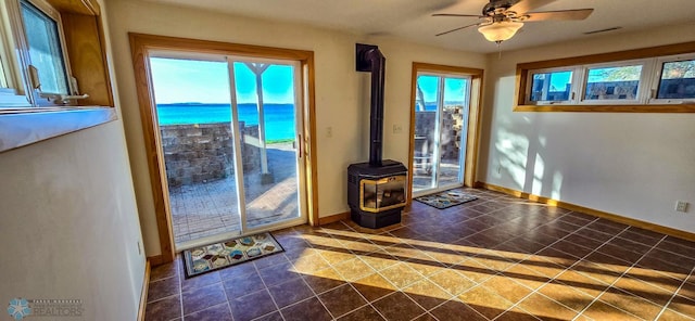 29972 293rd St, Little Elbow Twp, MN 56589 - doorway featuring a wood stove, baseboards, a water view, and a ceiling fan
