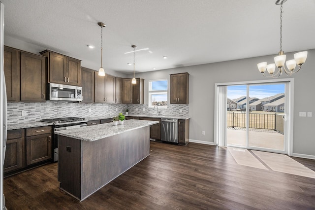 kitchen featuring backsplash, dark brown cabinetry, a chandelier, and stainless steel appliances