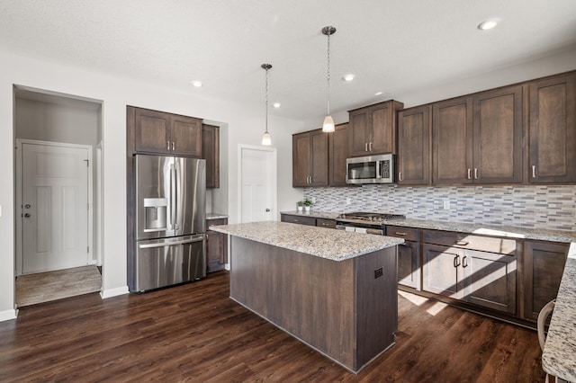kitchen featuring a center island, dark brown cabinetry, tasteful backsplash, and stainless steel appliances