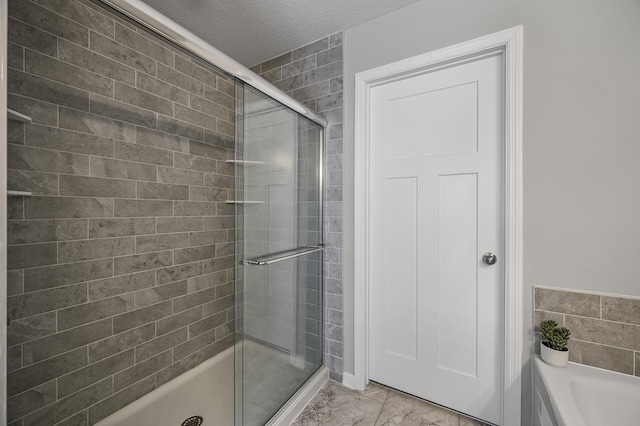 full bathroom with marble finish floor, a textured ceiling, and a stall shower