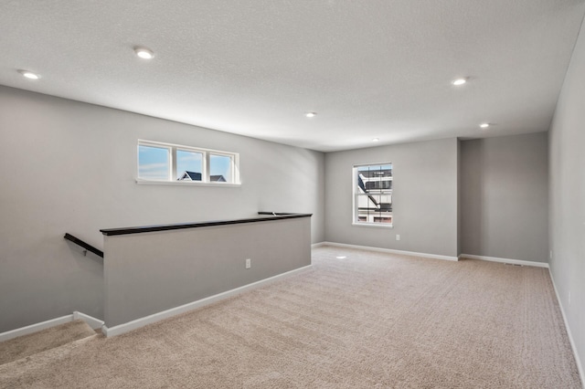 below grade area with recessed lighting, a wealth of natural light, and carpet