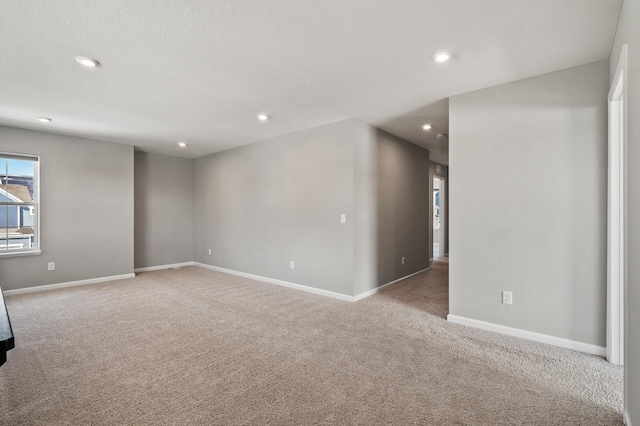 spare room with baseboards, recessed lighting, a textured ceiling, and carpet