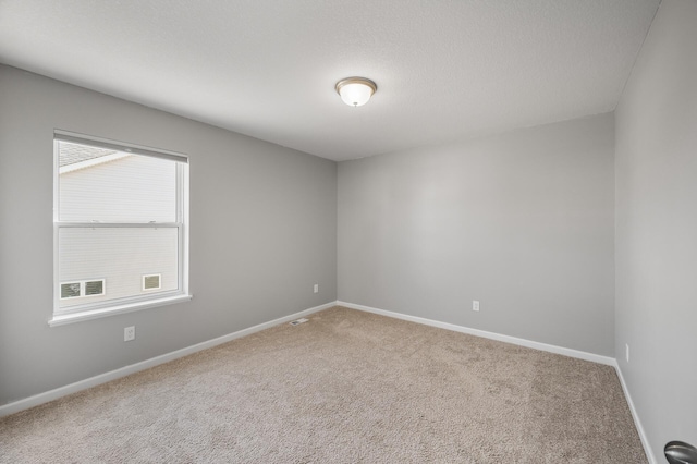 unfurnished room with carpet flooring and baseboards
