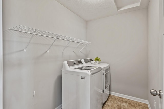laundry area with a textured ceiling, baseboards, independent washer and dryer, and laundry area