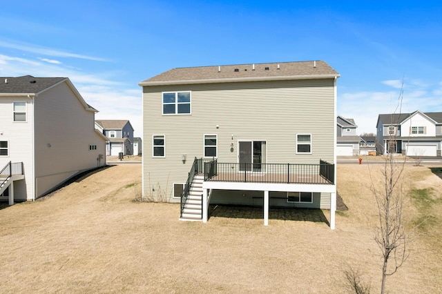 back of house featuring a residential view, a deck, and stairs