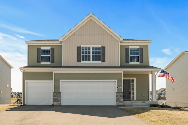 view of front of house featuring stone siding, a porch, driveway, and a garage