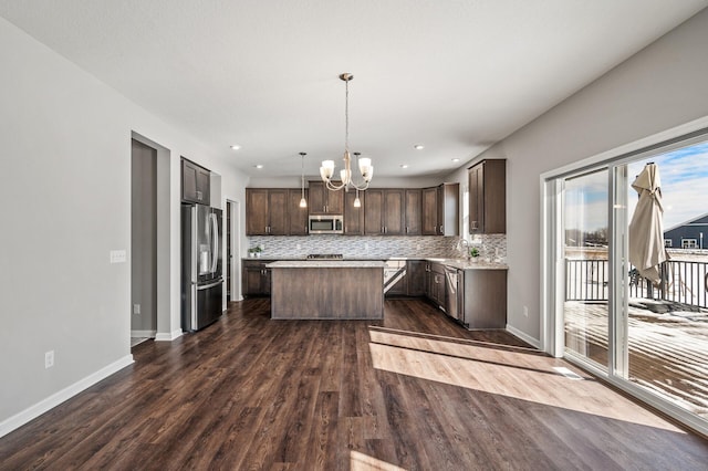 20147 79th Ave, Corcoran, MN 55340 - kitchen featuring appliances with stainless steel finishes, dark brown cabinets, a kitchen island, a chandelier, and tasteful backsplash