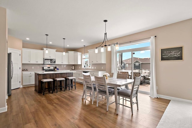 dining room with recessed lighting, baseboards, and wood finished floors