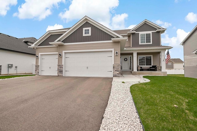 craftsman-style home featuring board and batten siding, a porch, driveway, an attached garage, and stone siding