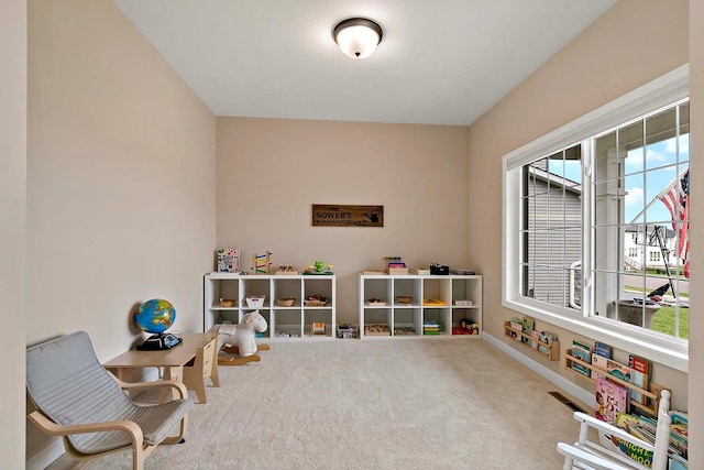 rec room with a healthy amount of sunlight, baseboards, and carpet flooring