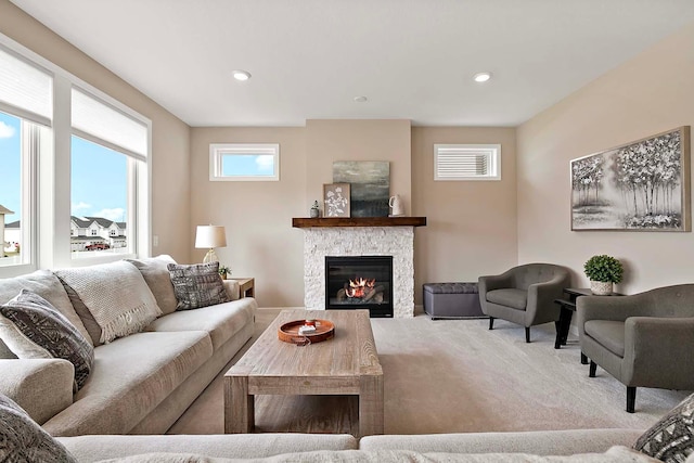 carpeted living room featuring recessed lighting, baseboards, visible vents, and a stone fireplace